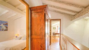 A bedroom with a wooden door, a bed, a nightstand, and a painting on the wall. - A Milella1 - VIGGIANELLO (VIGGIANELLO)