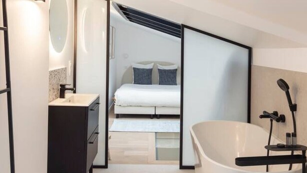 A compact, modern bathroom with a bathtub, a shower, and a small vanity. - Loft Design Alésia - Island bath - Métro 1mn (Paris)