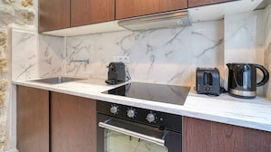 A compact kitchen with a marble backsplash, a built-in oven, a coffee maker, and a toaster. - Loft in Sentier - Paris - 6P - 2BR (Paris)