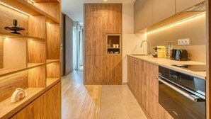 A modern kitchen with wooden cabinetry, a built-in oven, and a coffee machine. - Bois de Vincennes - Luxury & Balcony - 4P (Saint-Mandé)