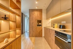 A modern kitchen with wooden cabinetry, a built-in oven, and a coffee machine. - Bois de Vincennes - Luxury & Balcony - 4P (Saint-Mandé)