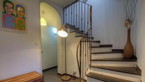 Un escalier avec une rampe en métal, un banc rond en bois et un lampadaire.