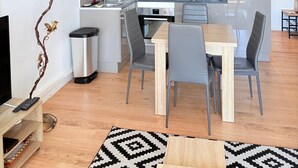 A modern kitchen with a dining area, a TV, and a decorative wall piece. - Beautiful setting with a terrace overlooking the sea (Saint-Cyprien)