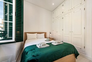 Ein Hotelzimmer mit einem Bett, einem Kleiderschrank und einem Fenster mit Jalousien.