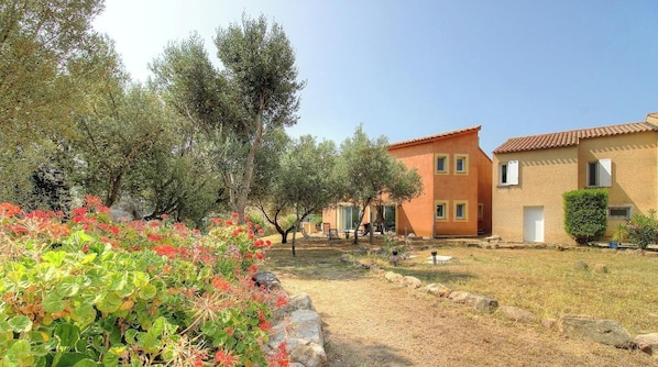 A residential area with a house featuring a tiled roof and a small garden with various plants. - Aja puzzuta - COTI CHIAVARI (COTI CHIAVARI)