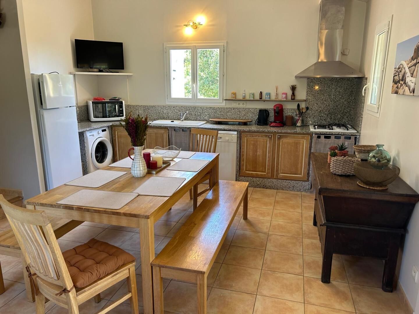 Una cocina compacta con comedor, lavadora, microondas y estufa a gas.