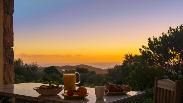 A table with breakfast items and a scenic view of the sunset. - Swimming pool, comfort and unspoilt surroundings: everything you need to discover the far south is here. (MONACIA D'AULLENE)