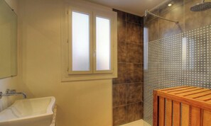 Ein Badezimmer mit einer Badewanne, einer Dusche und einem Fenster.