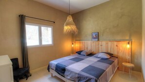 A bedroom with a bed, a window, a hanging light fixture, and a wooden headboard. - Calm - VIGGIANELLO - Gîte (VIGGIANELLO)