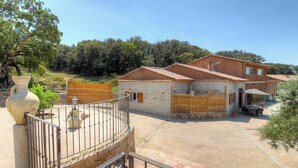 A two-story house with a stone facade, a balcony, and a patio area with outdoor furniture. - Calm - VIGGIANELLO - Gîte (VIGGIANELLO)