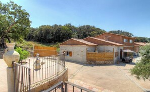 A two-story house with a stone facade, a balcony, and a patio area with outdoor furniture. - Calm - VIGGIANELLO - Gîte (VIGGIANELLO)