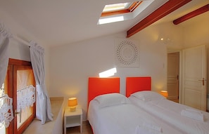 A hotel room with two beds, a skylight, a decorative wall piece, and a door. - I Monti Signori - OTA (OTA)