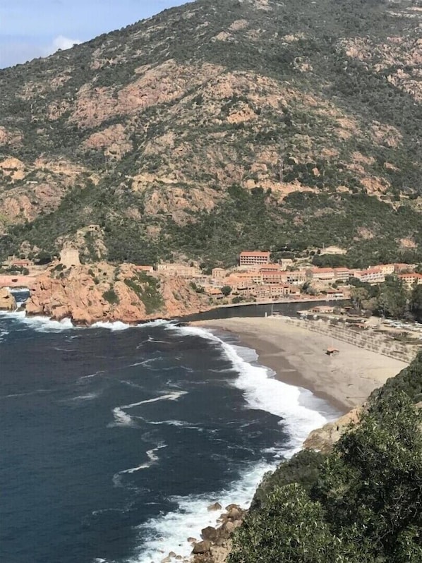 A coastal town with buildings along the beach, rocky cliffs, and a view of the sea. - I Monti Signori - OTA (OTA)