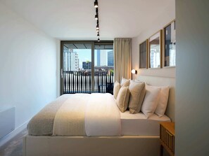 A modern bedroom with a large bed, a city view, and a minimalist design. - The Marengo at The Heim (Greater Manchester)