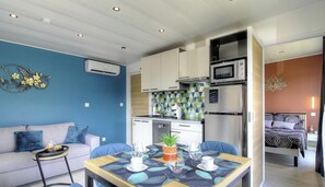 Ein kompakter Wohnbereich mit Küchenzeile, Essbereich und Schlafzimmer.