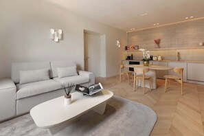 Ein modernes Wohnzimmer mit Sofa, Couchtisch und Essbereich.