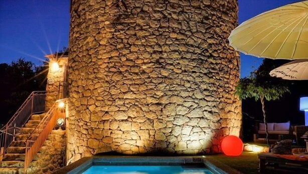 Una struttura in pietra con una piscina alla base.