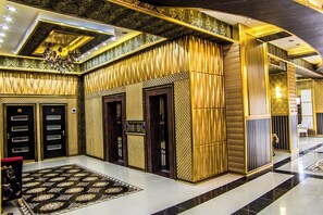 A luxurious lobby with a patterned carpet, a chandelier, and a modern design. - Golden Plaza Hotel (Baku)