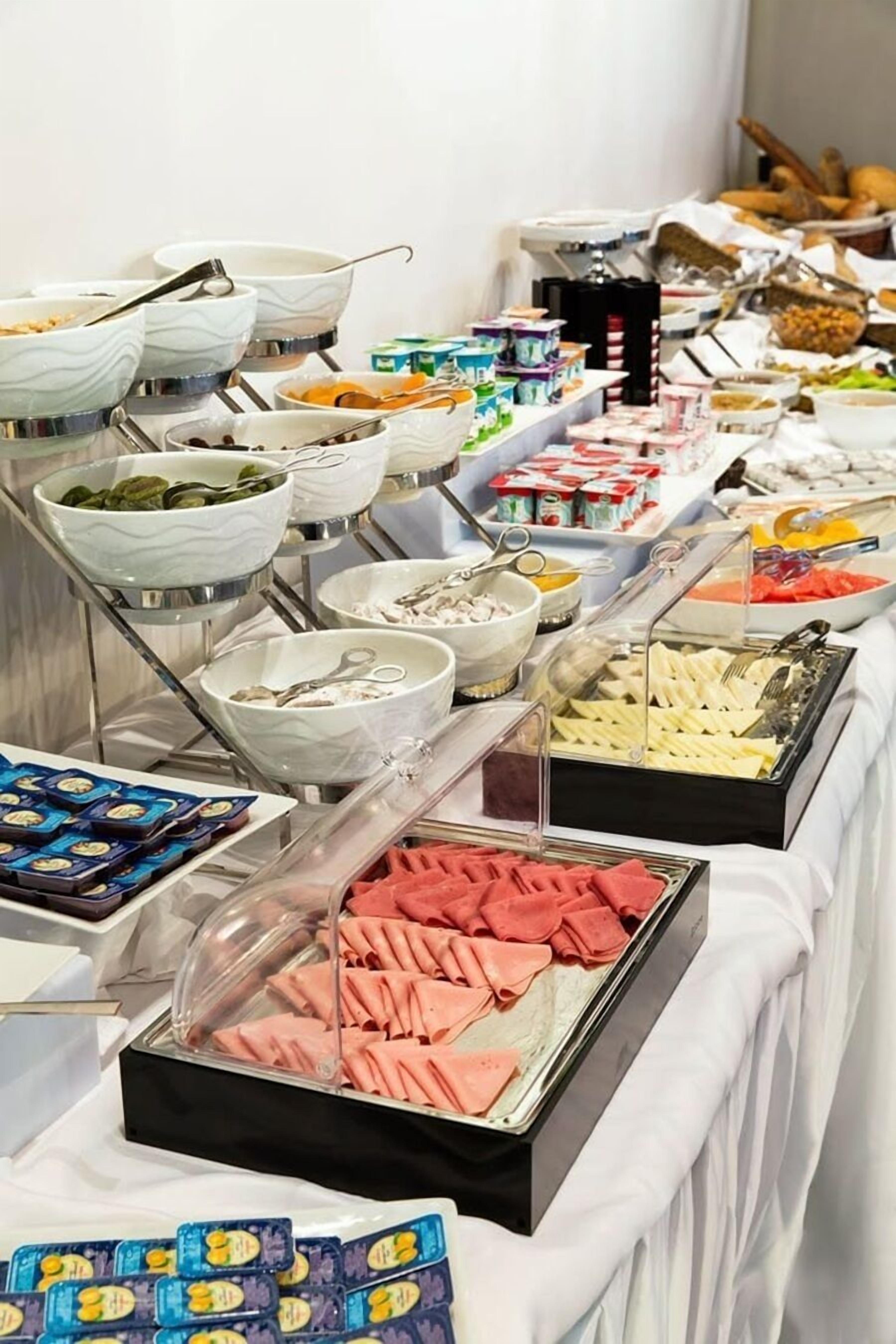 A buffet with various food items and utensils.