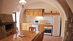 Una cocina con armarios de madera, microondas, estufa y refrigerador.