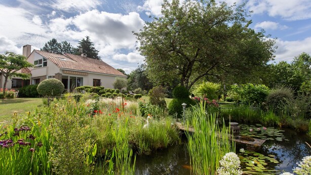 A house with a garden, a pond, and a tree. - Guest Room “La Grange Fleurie” with Shared Terrace, Garden, and Wi-Fi (Rochechouart)