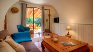 A cozy living room with a sofa, a coffee table, a TV, and a dining area with chairs and a table. - U Pagliaghju - SPELONCATO (SPELONCATO)