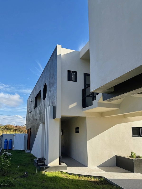 A modern building with a flat roof, large windows, and a concrete facade.