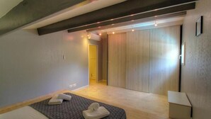 Un dormitorio moderno con cama, armario de madera y mesita de noche.