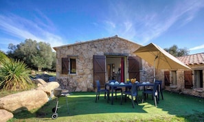 A stone house with a patio, a grill, and a table set for dining. - Petralonga sheepfold (SOTTA)