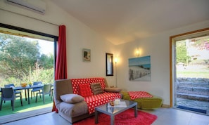 A living room with a sofa, coffee table, and chairs, a dining table with chairs, a painting, and a view of the outdoors. - Petralonga sheepfold (SOTTA)