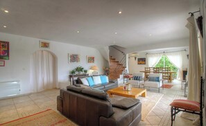 A spacious living room with a sofa, coffee table, and a staircase leading to an upper level. - Le 26991 - SAN GAVINO DI CARBINI (SAN GAVINO DI CARBINI)