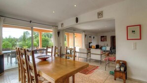 Un comedor amplio con una gran mesa de madera, sillas y vistas al exterior.