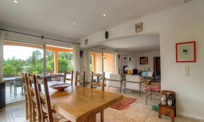 A spacious dining area with a large wooden table, chairs, and a view of the outdoors. - Le 26991 - SAN GAVINO DI CARBINI (SAN GAVINO DI CARBINI)