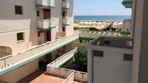 A multi-story hotel with balconies, a pool area, and a view of the beach. - Sea view flat in Bibione for four guests (Bibione)