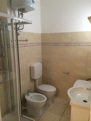 A bathroom with a shower, two toilets, and a sink. - Sea view flat in Bibione for four guests (Bibione)