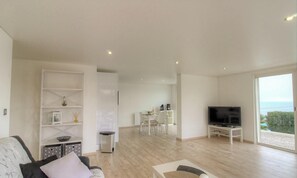 A modern living room with a TV, sofa, and dining area. - Villa di Charma Marion (CALCATOGGIO)