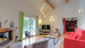 A spacious living room with a fireplace, a television, and a red sofa. - In the Meadow of the Kites - CUTTOLI CORTICCHIATO (CUTTOLI CORTICCHIATO)
