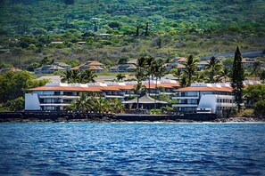 Ein Küstenhotel mit mehreren Gebäuden, einer felsigen Küstenlinie und Blick auf den Ozean.
