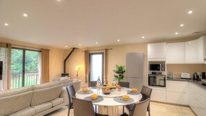 Una cocina moderna con comedor, que incluye un sofá, una mesa y varios electrodomésticos.