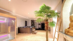 Un interior moderno con zona de spa, una isla central con hidromasaje y una gran estatua de Buda.