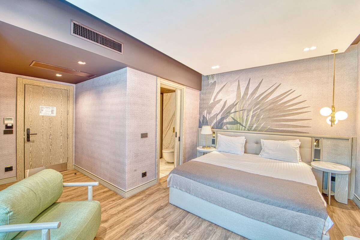 Une chambre d’hôtel moderne dotée d’un grand lit, d’un coin salon et d’une salle de bain.
