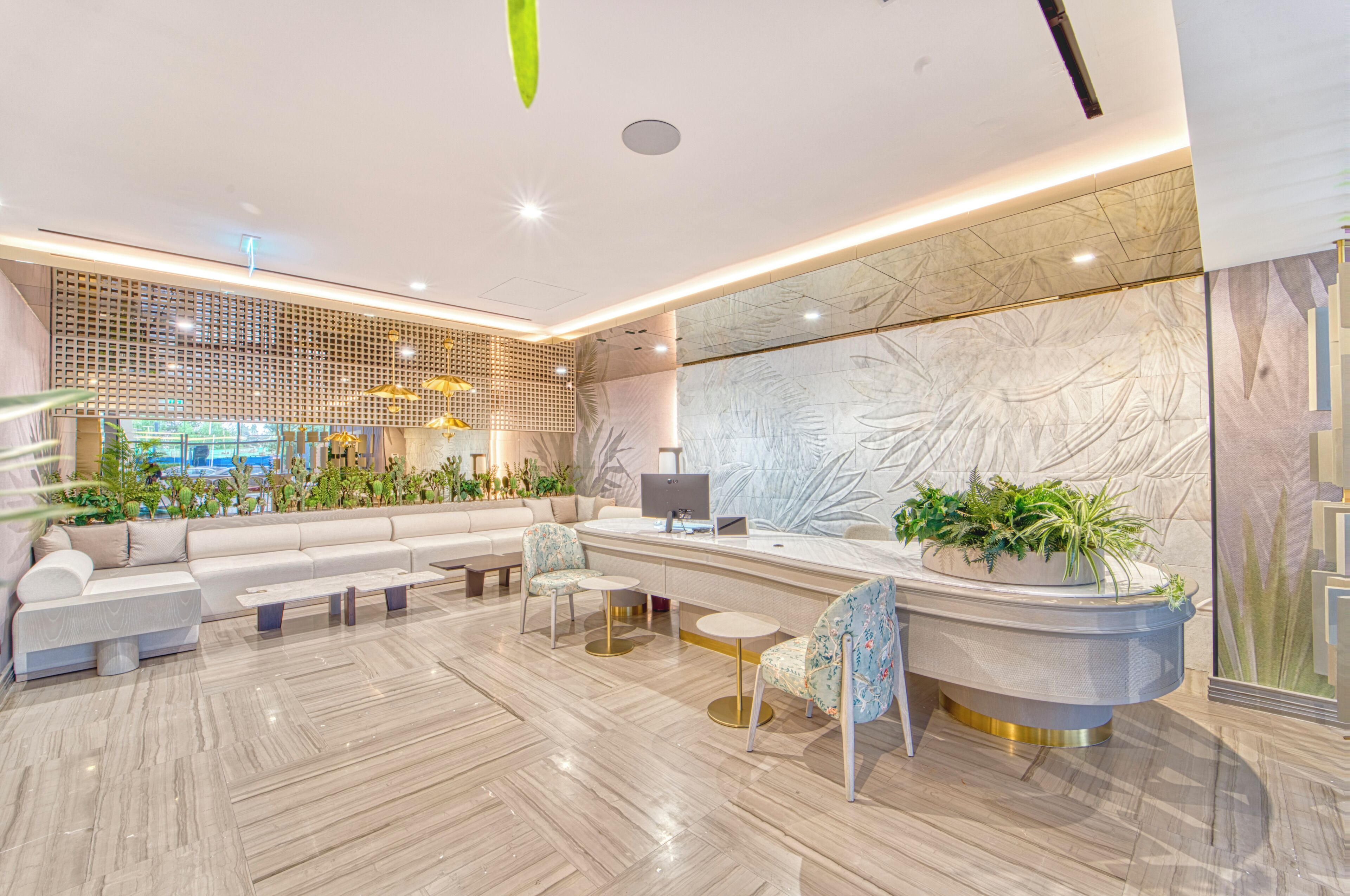Eine moderne Lobby mit Sitzgelegenheiten, einem Empfangsbereich und einer großen Wandgestalt.