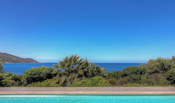 Una piscina con vistas al mar y a las colinas.