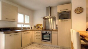 A modern kitchen with stainless steel appliances, a built-in oven, and a coffee maker. - Casa Paterna - VENACO (VENACO)