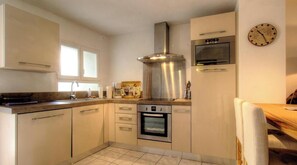 A modern kitchen with stainless steel appliances, a built-in oven, and a coffee maker. - Casa Paterna - VENACO (VENACO)