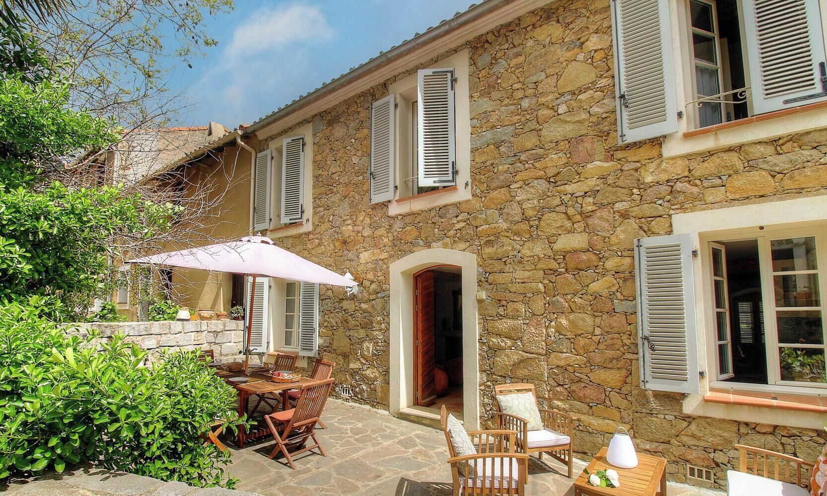 A stone building with a patio area, outdoor furniture, and a door leading to an interior space.