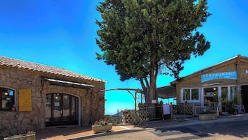 Ein Steinhaus mit einem Restaurant namens 'RESTAURANT' und einer Bar namens 'Pietra' auf der rechten Seite.