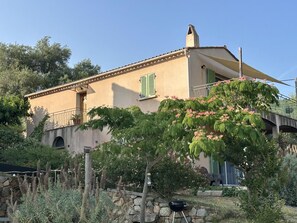 Ein Gebäude im mediterranen Stil mit einer Steinfassade, einem Balkon und Blick auf eine Brücke.