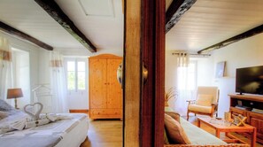 A room with a bed, a wooden wardrobe, a television, and a sofa. - A Casa Di I Ricordi - SISCO (SISCO)