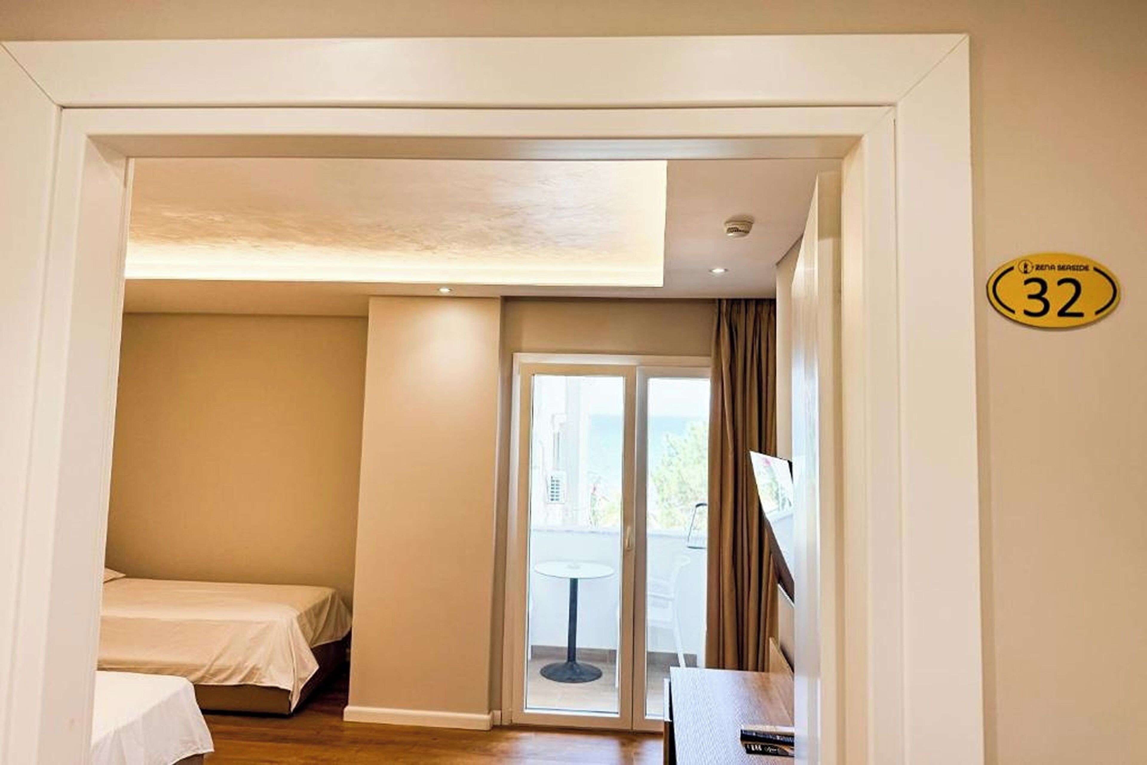 A hotel room with a bed, a desk, and a view of the outside.